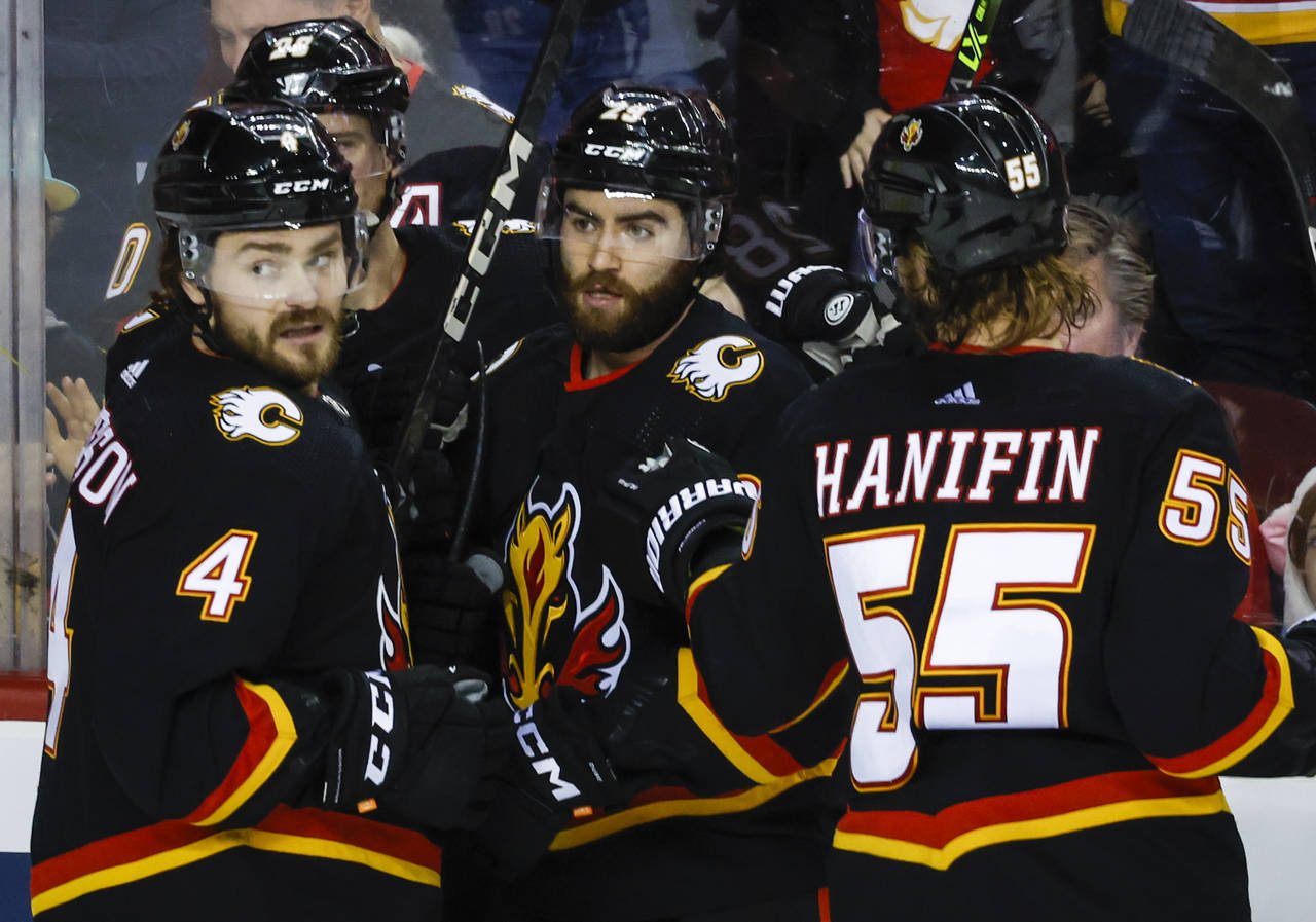 Calgary Flames forward Dillon Dube, center, celebrates his goal with teammates Rasmus Andersson, le...