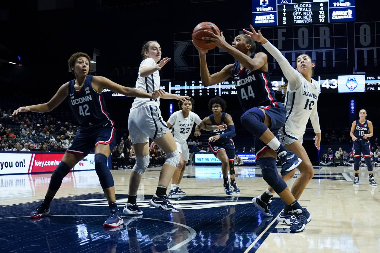 UConn forward Aubrey Griffin (44) drives against Xavier's Fernanda Ovalle (10) during the first hal...