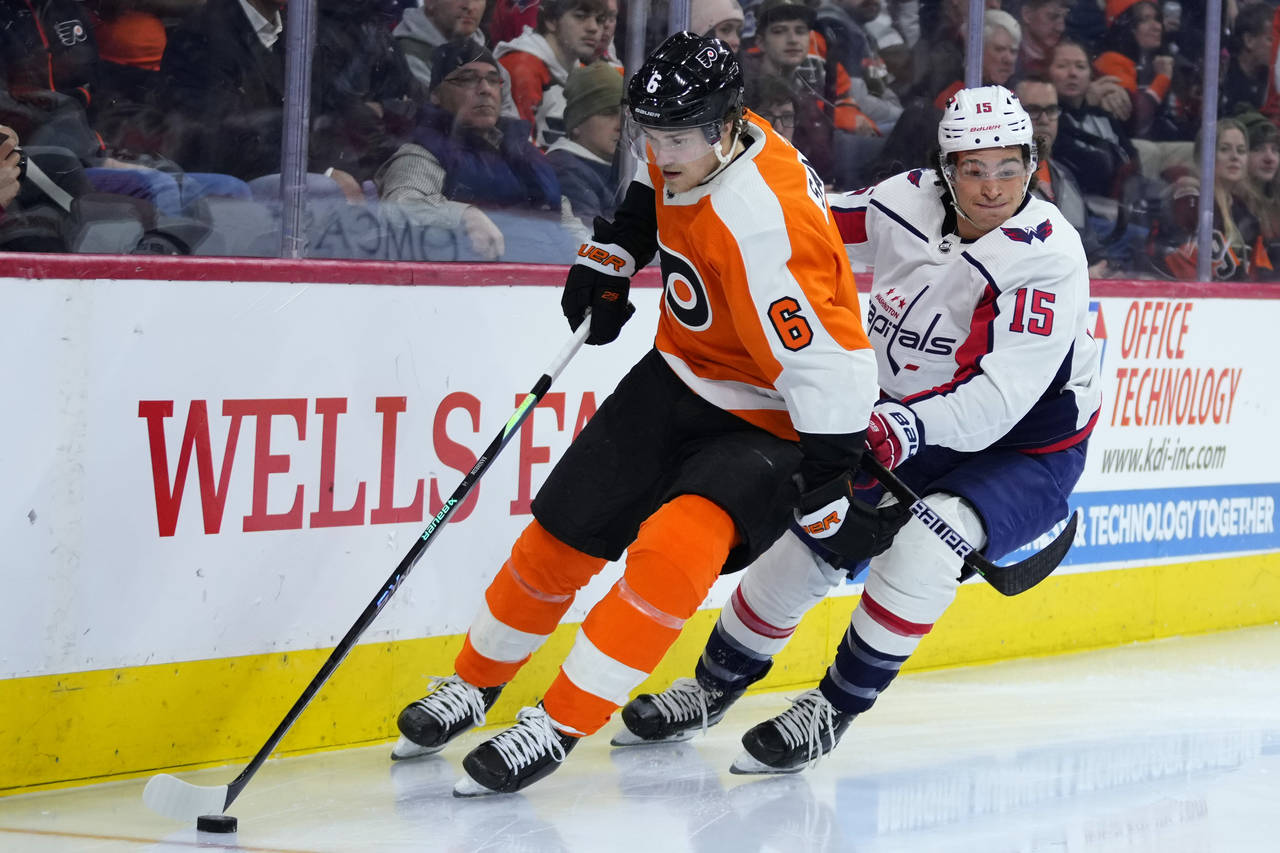 Philadelphia Flyers' Travis Sanheim, left, tries to keep away from Washington Capitals' Sonny Milan...