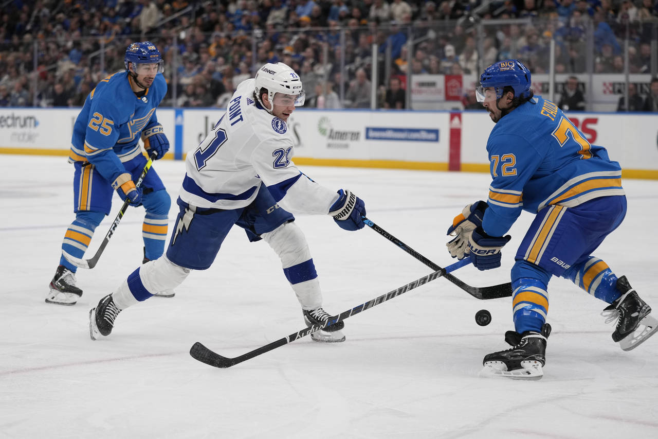 Tampa Bay Lightning's Brayden Point (21) shoots as St. Louis Blues' Justin Faulk (72) and Jordan Ky...