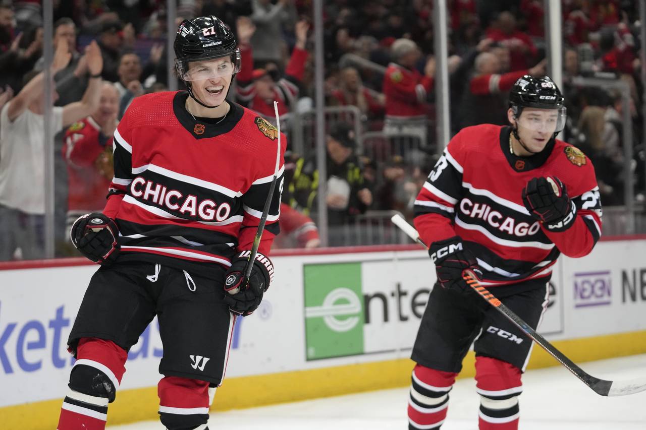Chicago Blackhawks left wing Lukas Reichel, left, celebrates after his first NHL hockey career goal...