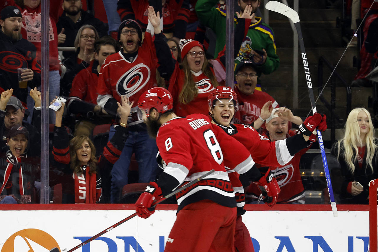Carolina Hurricanes' Brent Burns (8) celebrates his goal with teammate Jesperi Kotkaniemi (82) duri...