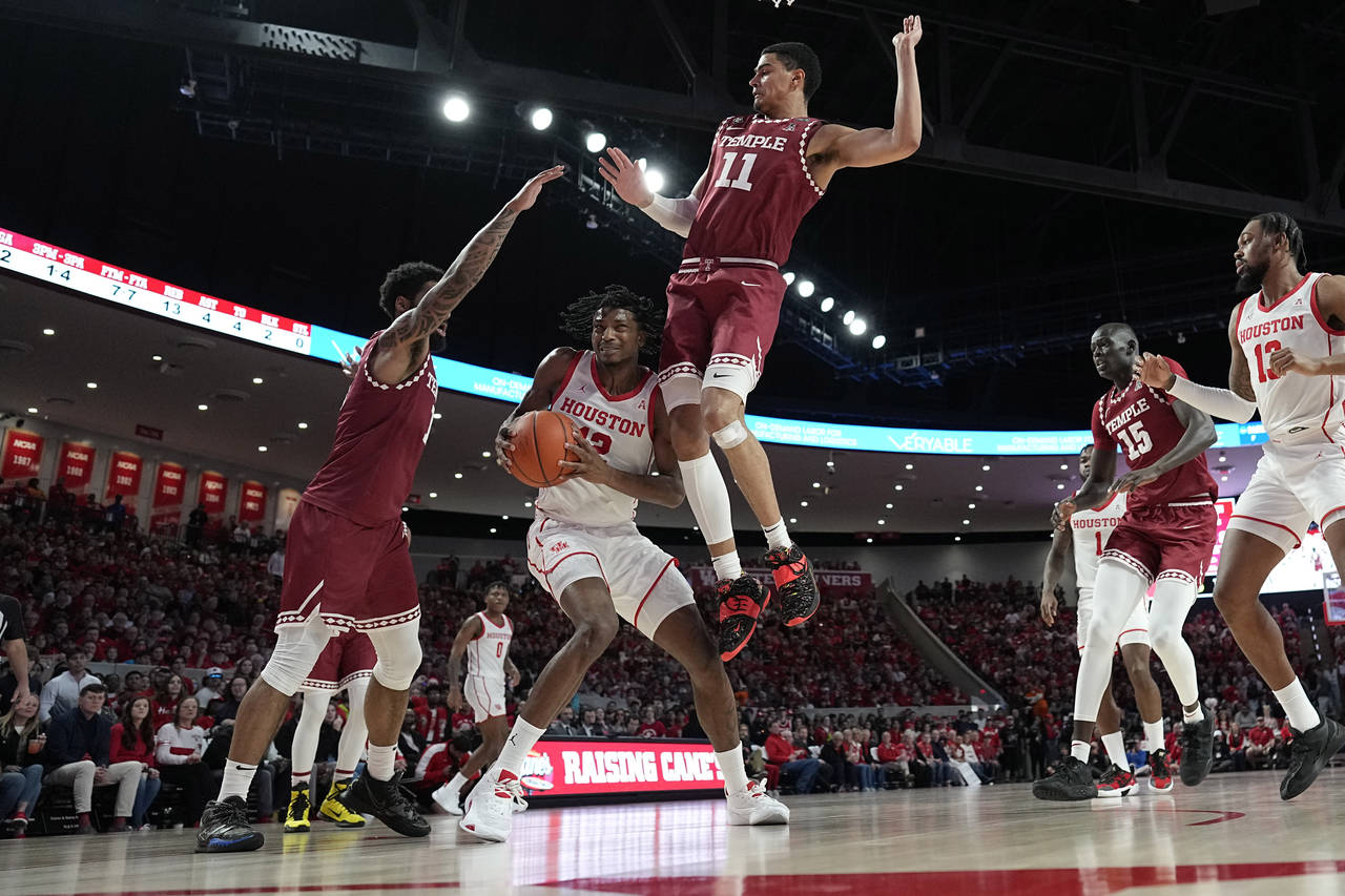 Houston's Tramon Mark (12) is fouled by Temple's Nick Jourdain (11) as Damian Dunn (1) helps defend...