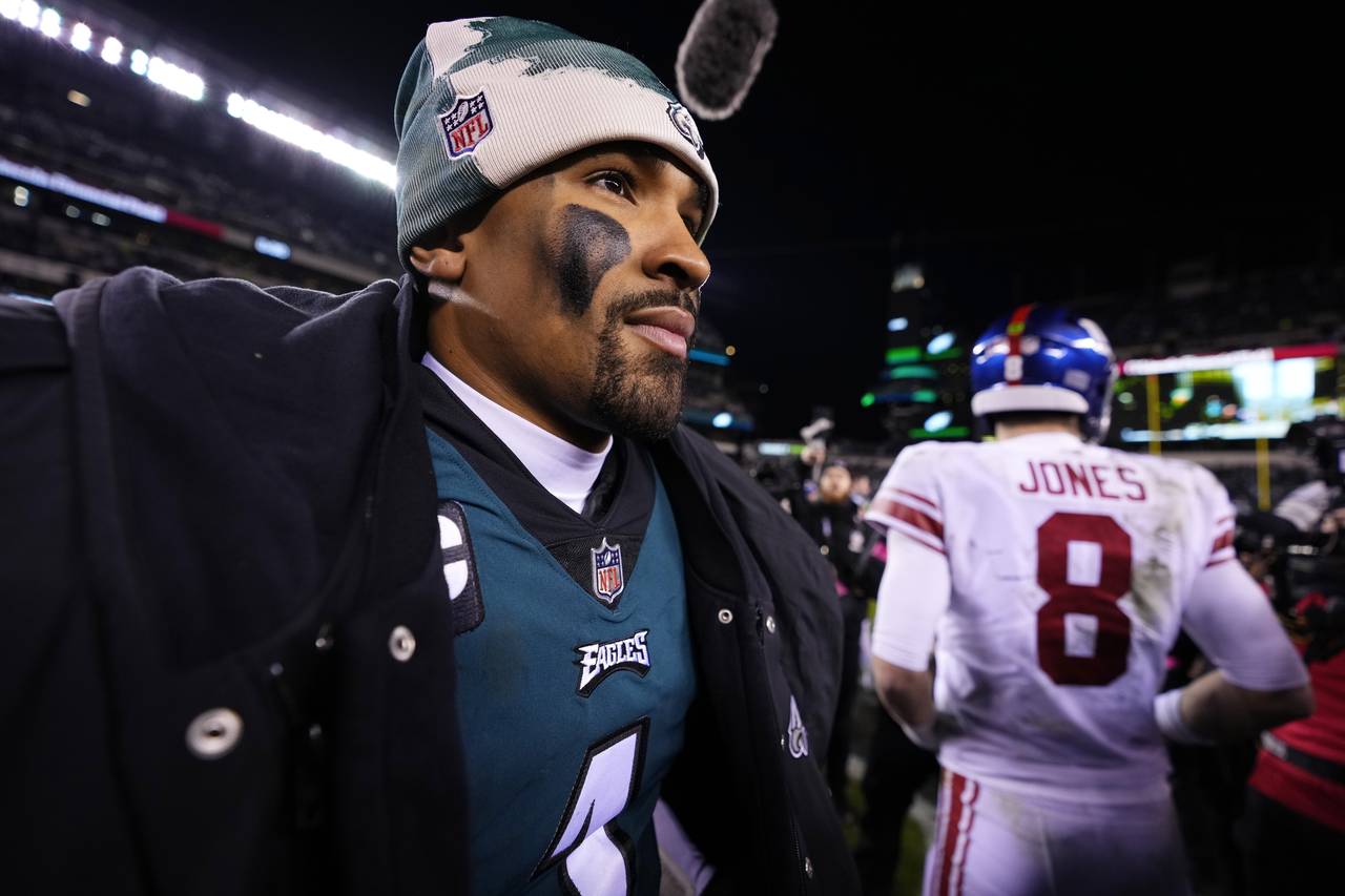 Philadelphia Eagles quarterback Jalen Hurts, left, looks on after talking with New York Giants quar...