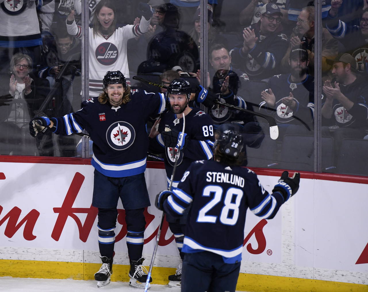 Winnipeg Jets' Axel Jonsson-Fjallby (71) celebrates his goal against the Vancouver Canucks with Sam...