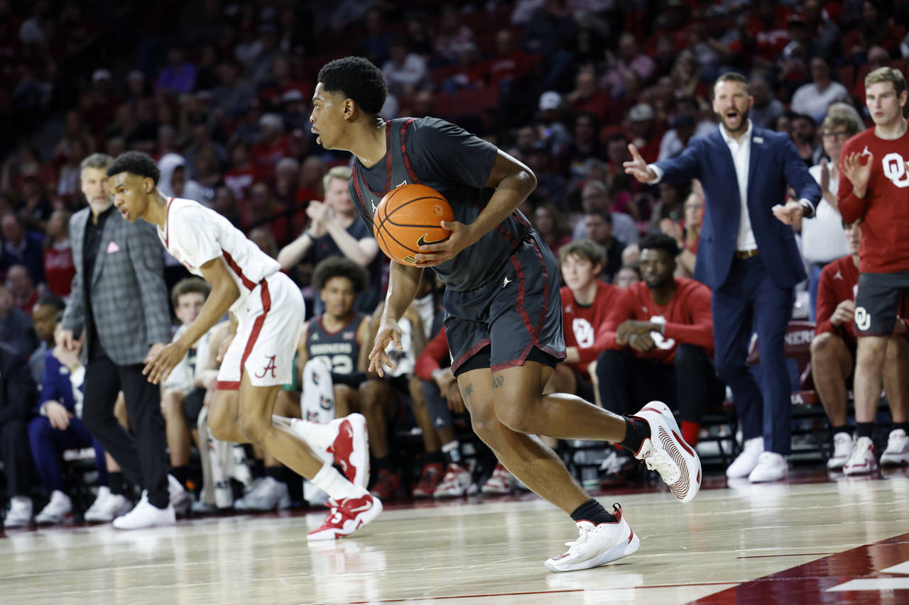 Oklahoma guard Grant Sherfield (25) brings the ball up the court during the first half of an NCAA c...