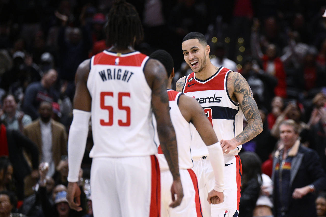Washington Wizards forward Kyle Kuzma, right, reacts with guard Monte Morris, center, and guard Del...