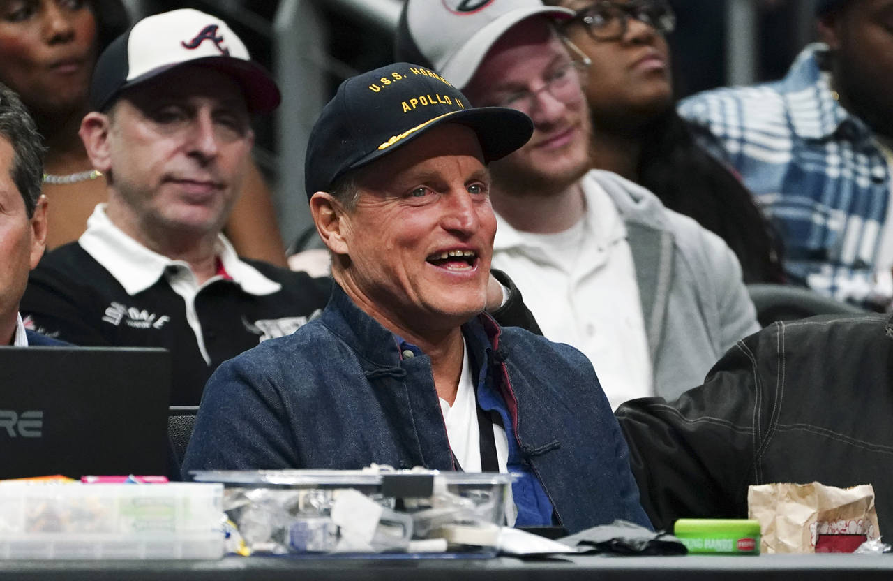 Actor Woody Harrelson laughs as he watches the second half of an NBA basketball game between Los An...