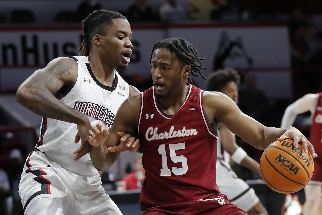 Charleston's Pat Robinson III (15) drives against Northeastern's Jahmyl Telfort during the first ha...