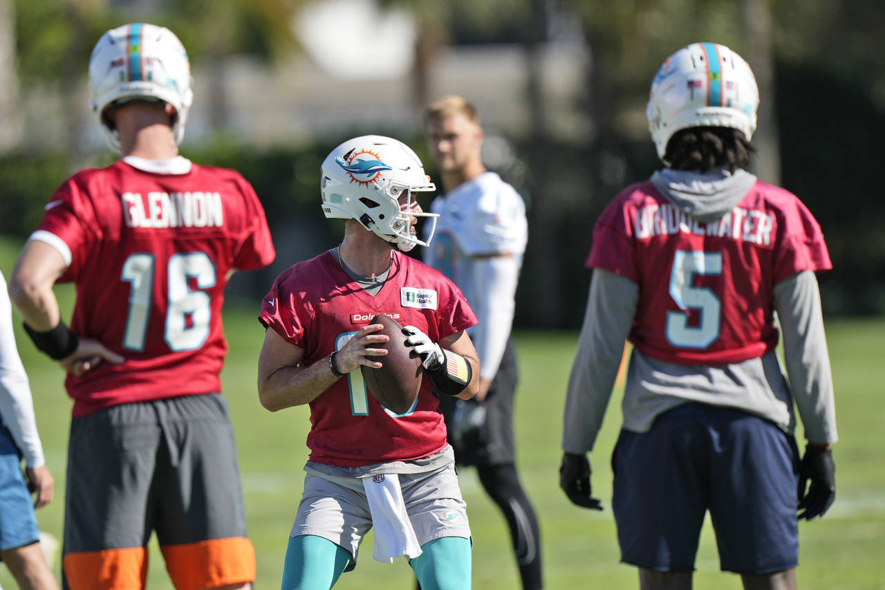Miami Dolphins quarterback Skylar Thompson, center, runs a drill as Teddy Bridgewater (5) and pract...