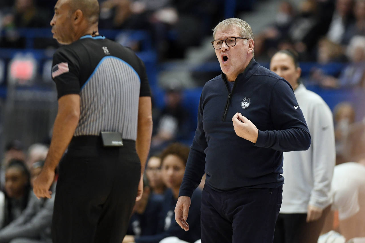 UConn head coach Geno Auriemma, right, calls to an official in the first half of an NCAA college ba...