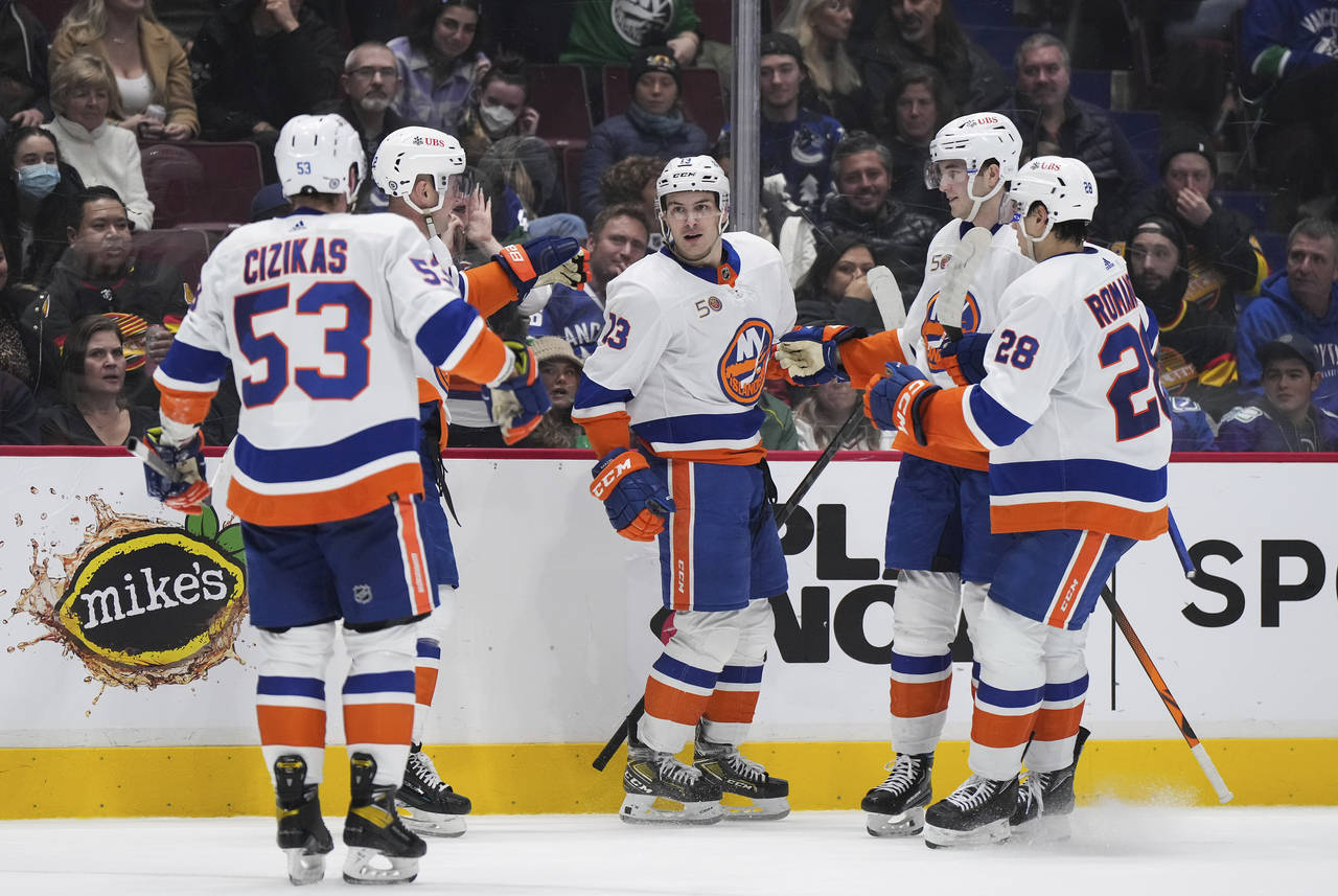 New York Islanders' Mathew Barzal, center, celebrates his goal against the Vancouver Canucks with C...