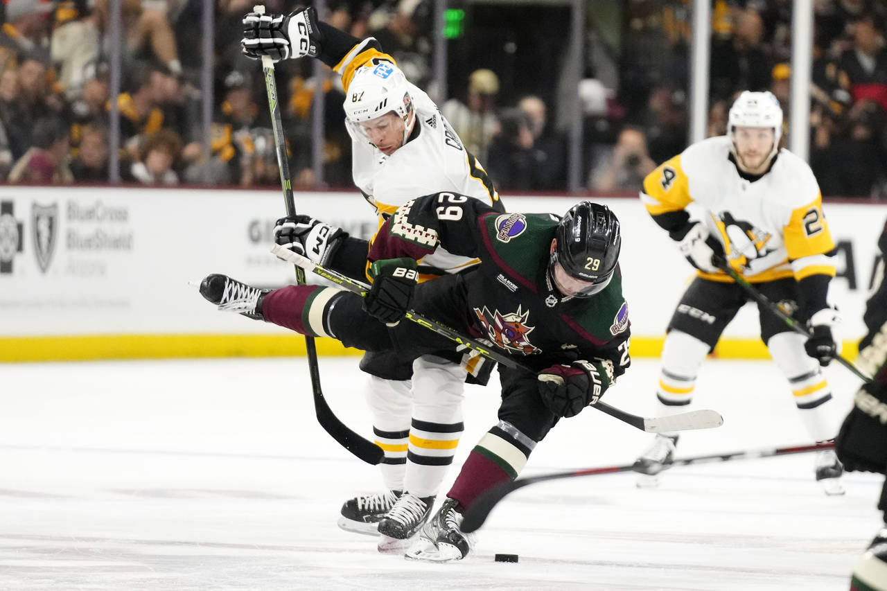 Pittsburgh Penguins center Sidney Crosby sends Arizona Coyotes center Barrett Hayton (29) to the ic...
