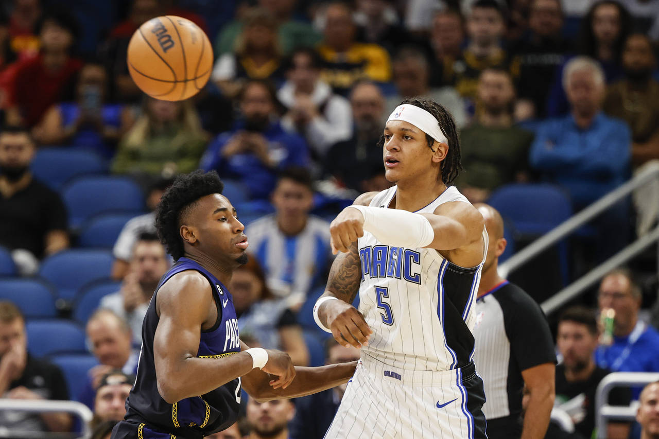 Orlando Magic forward Paolo Banchero (5) passes the ball while defended by Indiana Pacers forward A...