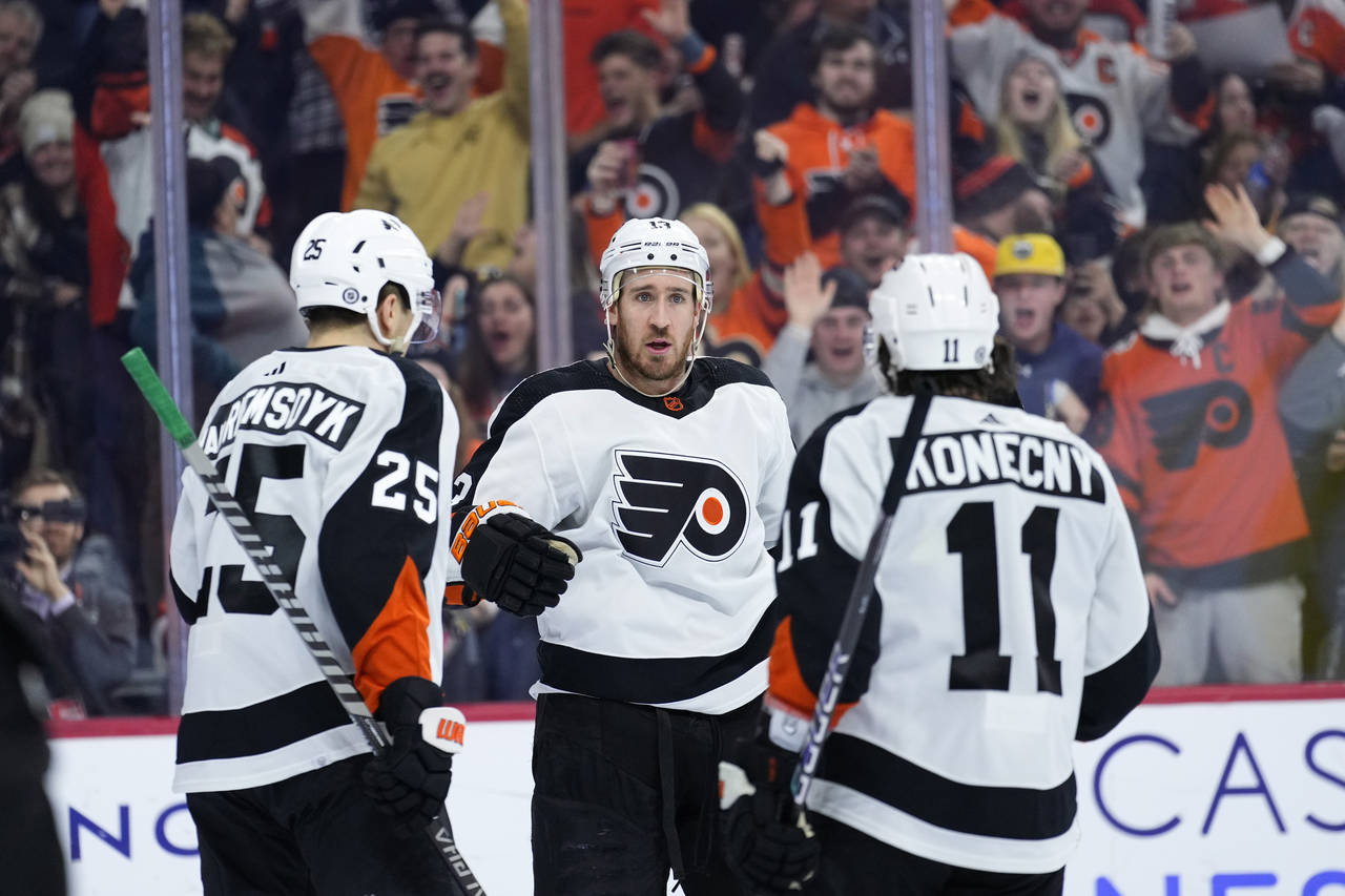 Philadelphia Flyers' Kevin Hayes, center, celebrates with James van Riemsdyk, left, and Travis Kone...
