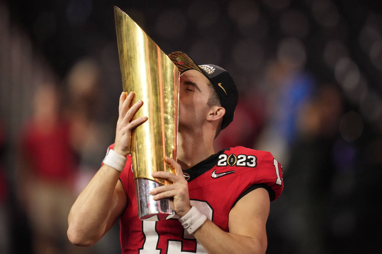 Georgia quarterback Stetson Bennett (13) kisses the championship trophy after the national champion...