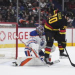 Oilers beat reeling Canucks 4-2 for 6th straight victory.
