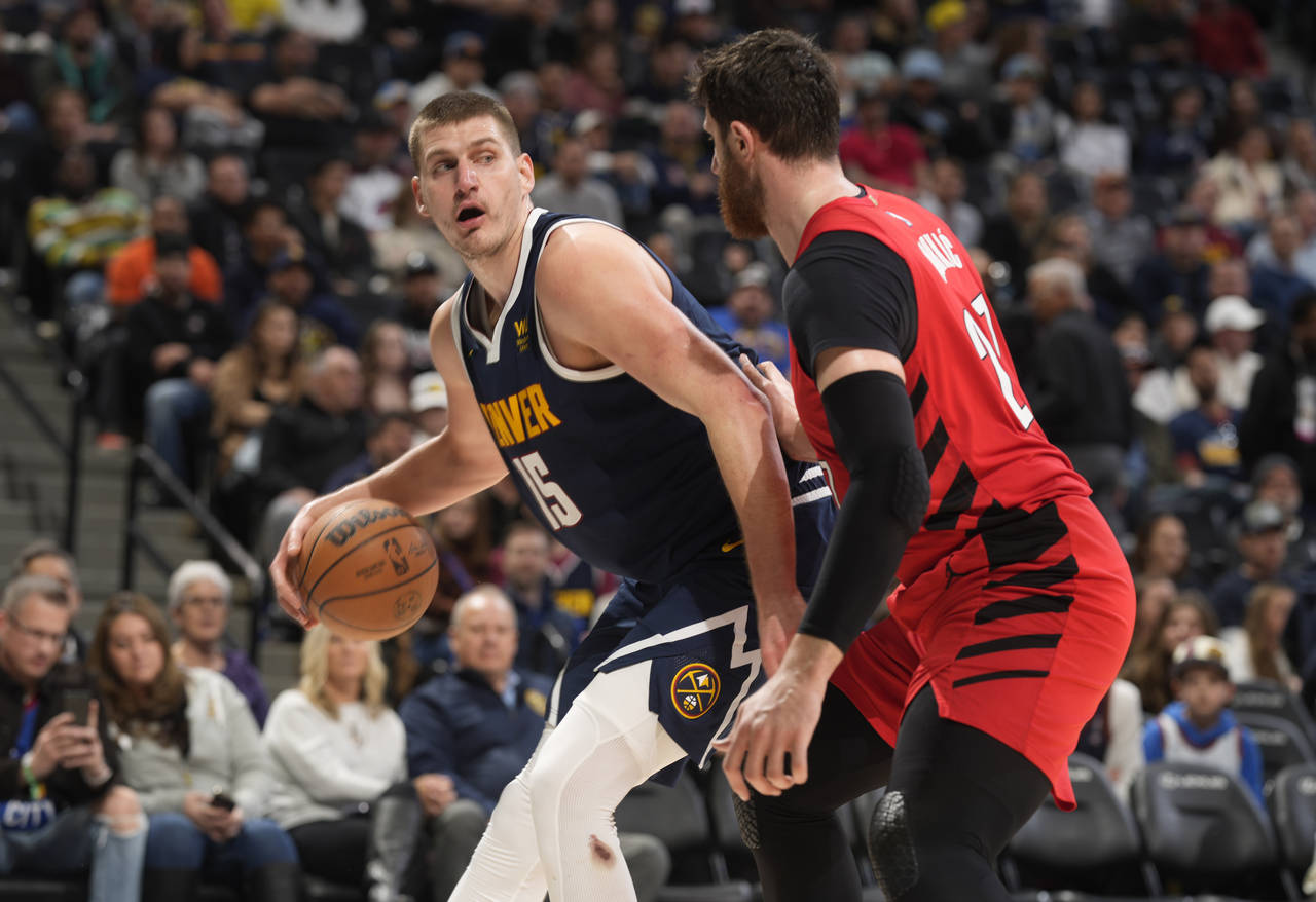 Denver Nuggets center Nikola Jokic, left, is defended by Portland Trail Blazers center Jusuf Nurkic...