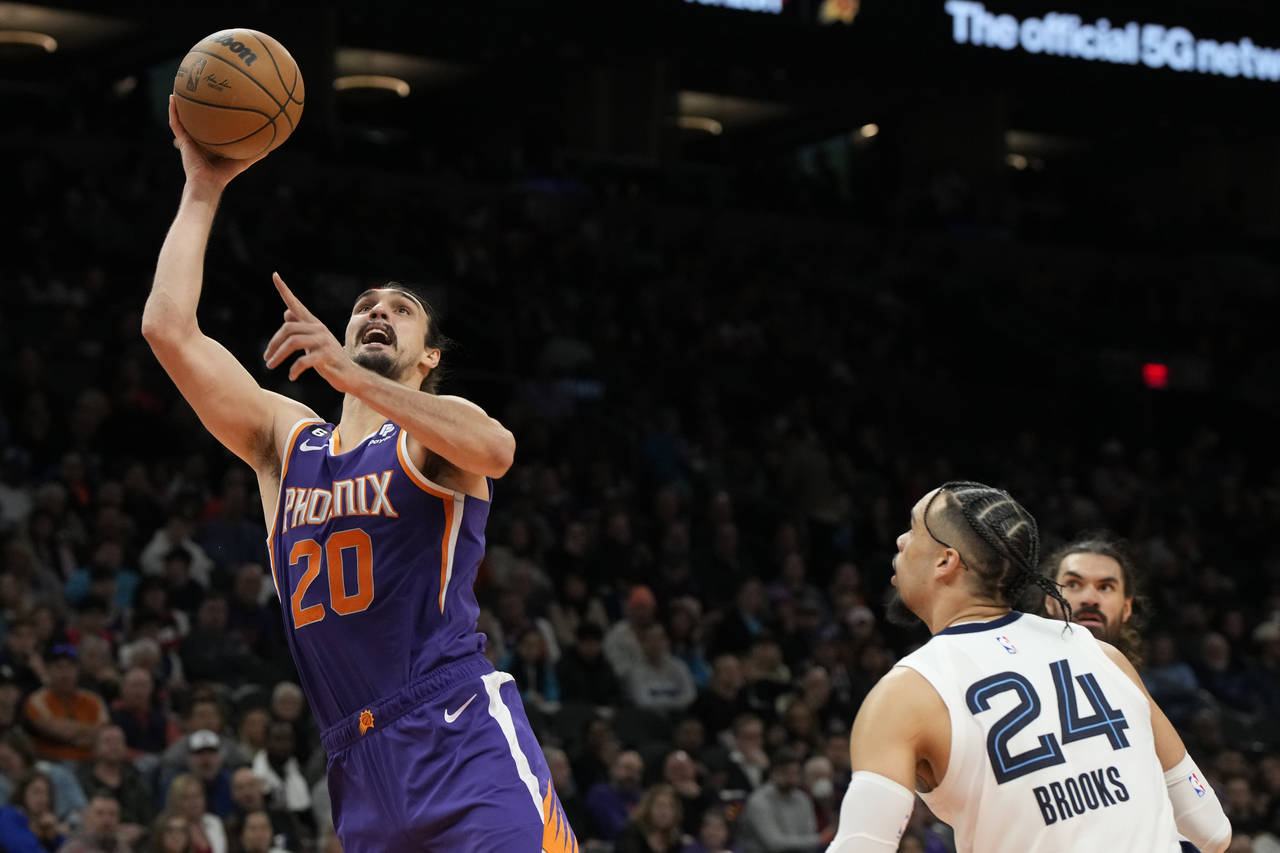 Phoenix Suns forward Dario Saric (20) drives past Memphis Grizzlies forward Dillon Brooks (24) duri...