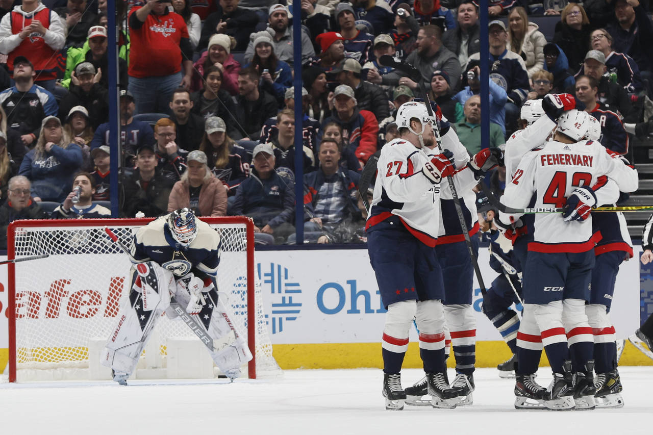 Washington Capitals players celebrate their goal against Columbus Blue Jackets' Elvis Merzlikins du...
