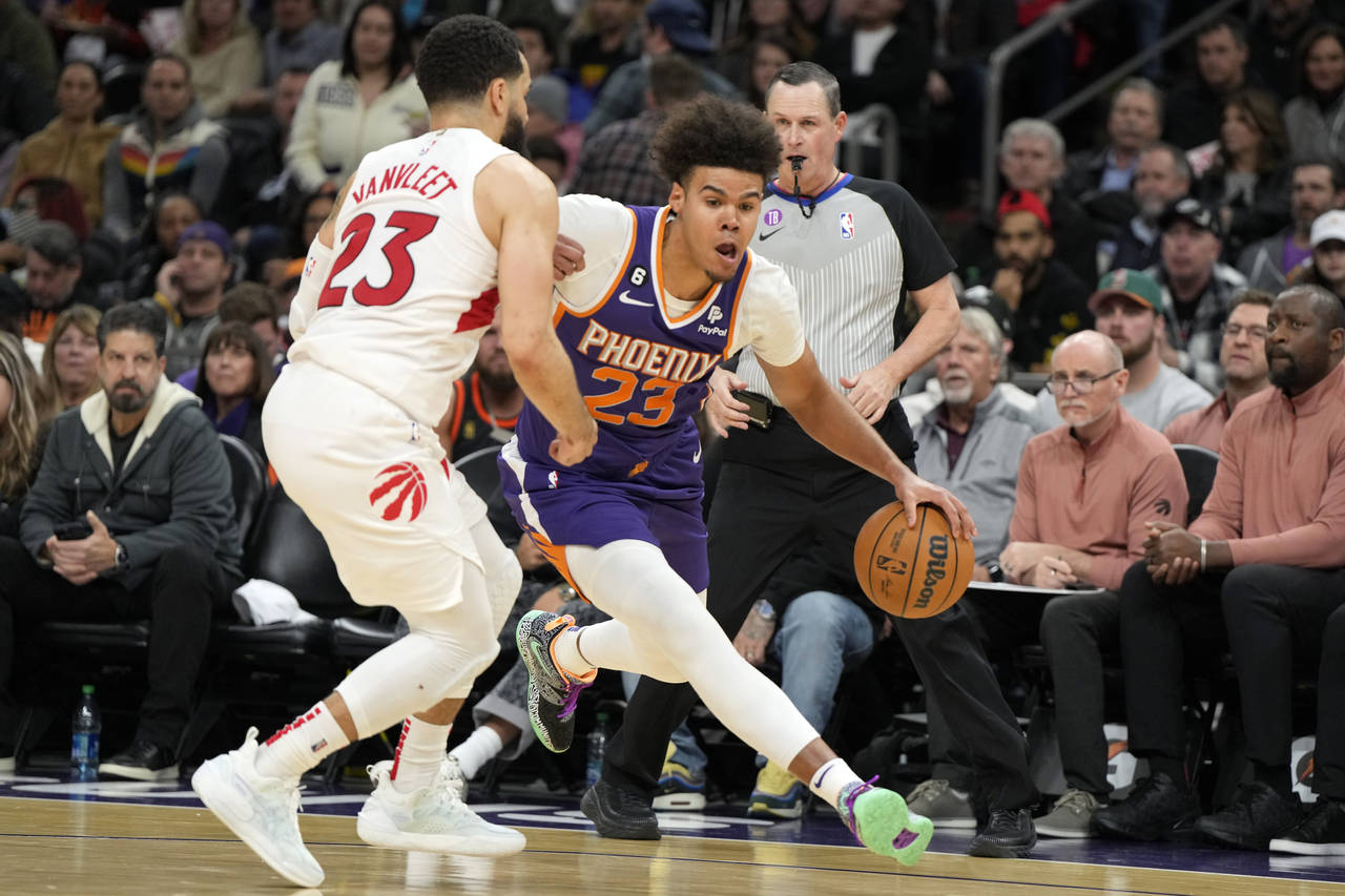 Phoenix Suns forward Cameron Johnson, right, drives against Toronto Raptors guard Fred VanVleet, le...