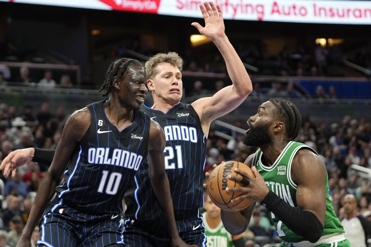 Boston Celtics guard Jaylen Brown, right, looks for a shot against Orlando Magic's Bol Bol (10) and...