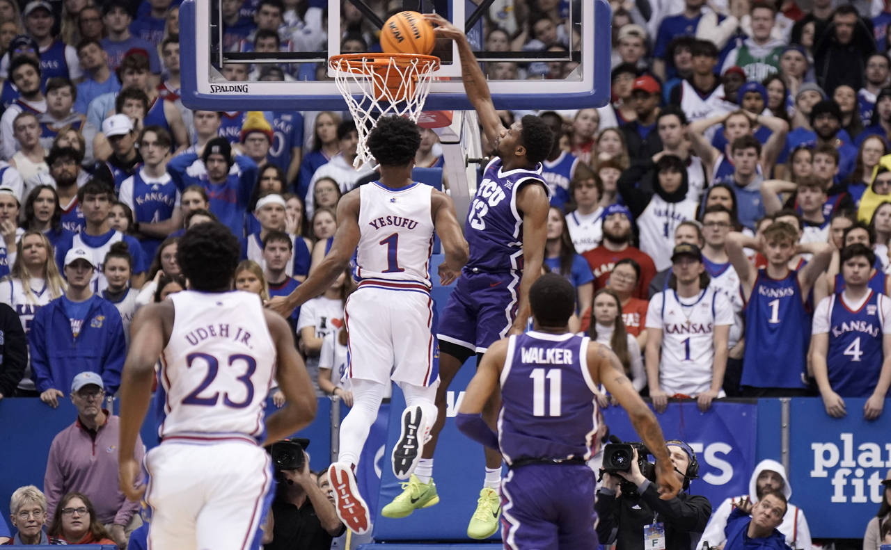 TCU guard Shahada Wells (13) comes in for a dunk past Kansas guard Joseph Yesufu (1) during the fir...