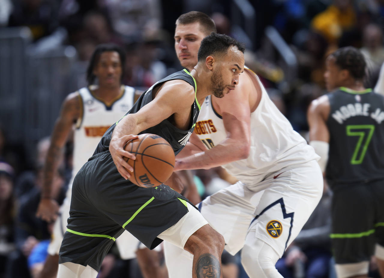 Minnesota Timberwolves forward Kyle Anderson drives againt Denver Nuggets center Nikola Jokic durin...