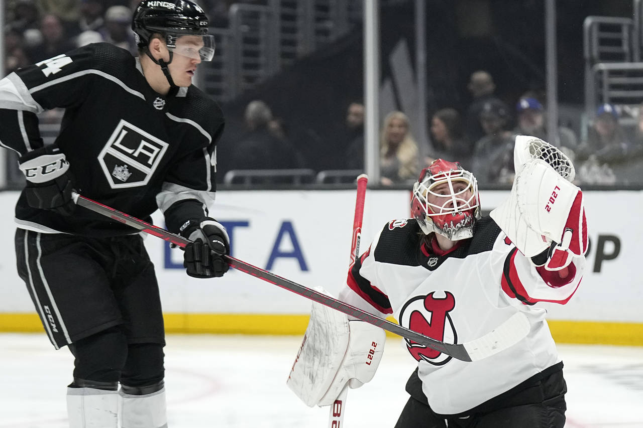 New Jersey Devils goaltender Mackenzie Blackwood, right, makes a glove save as Los Angeles Kings de...