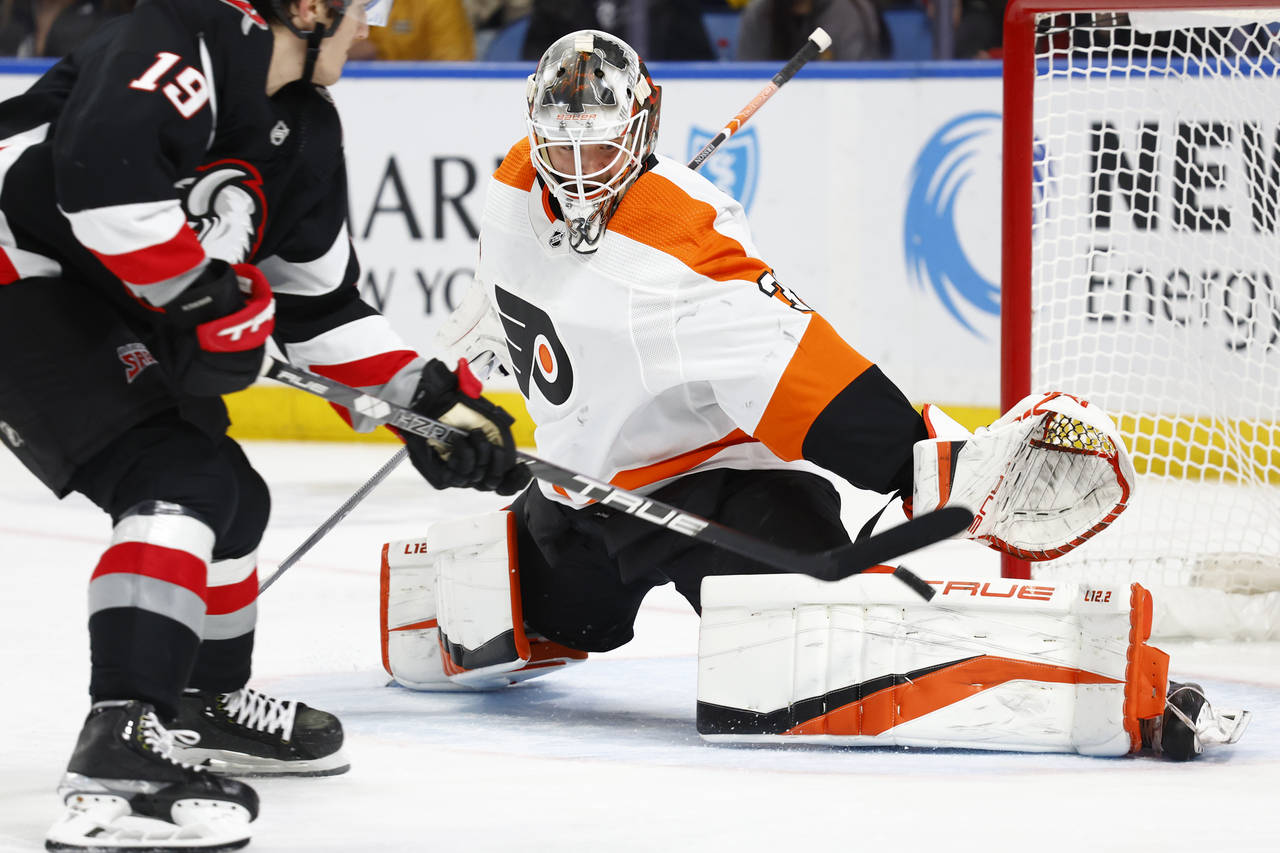 Philadelphia Flyers goaltender Samuel Ersson, right, makes a save against Buffalo Sabres center Pey...