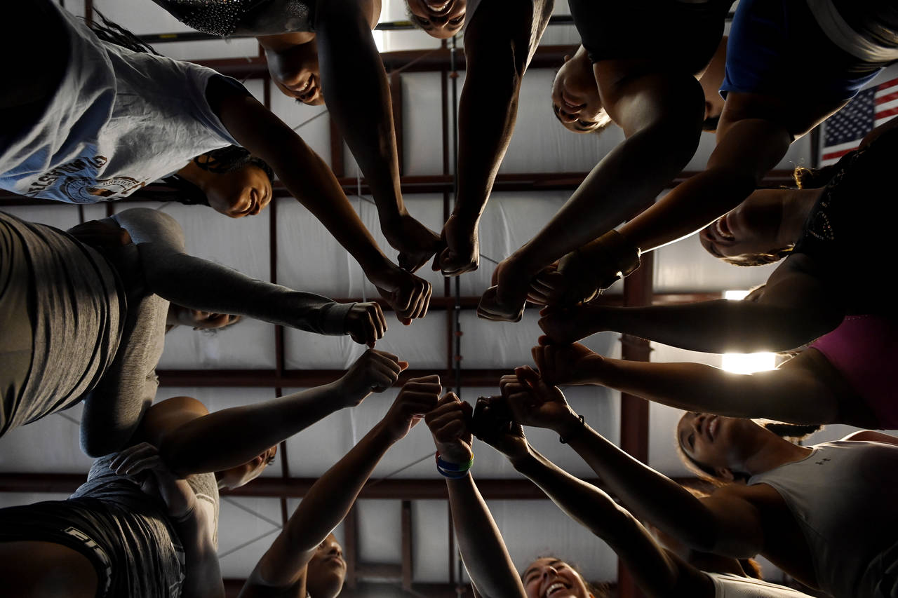 Fisk University gymnastics team gathers in a circle for a cheer during practice at the Nashville Gy...
