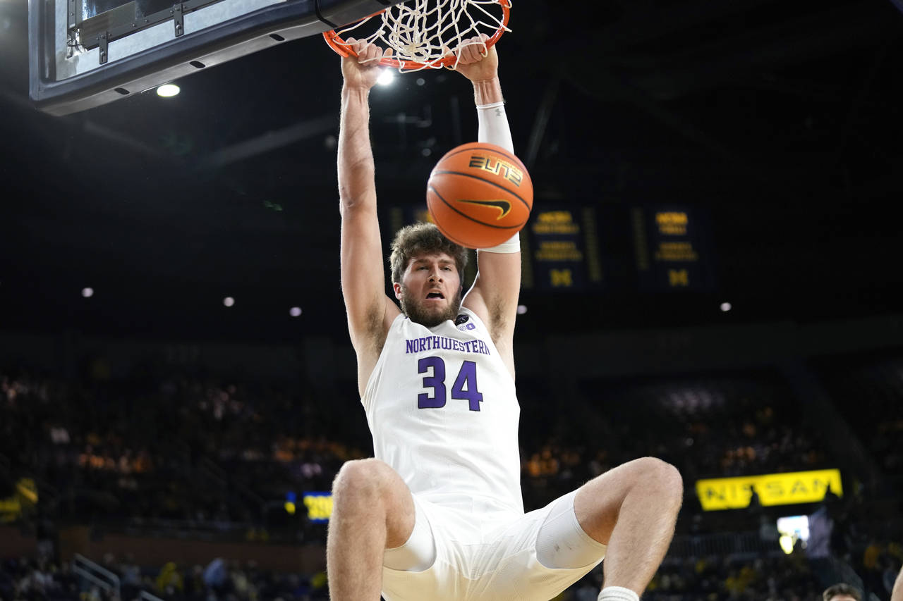 Northwestern center Matthew Nicholson (34) dunks against Michigan in the first half of an NCAA coll...