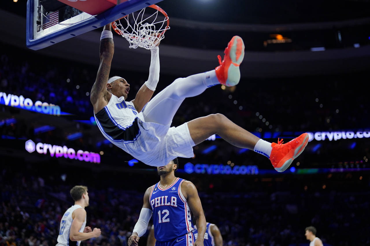 Orlando Magic's Paolo Banchero, top, dunks during the second half of an NBA basketball game against...