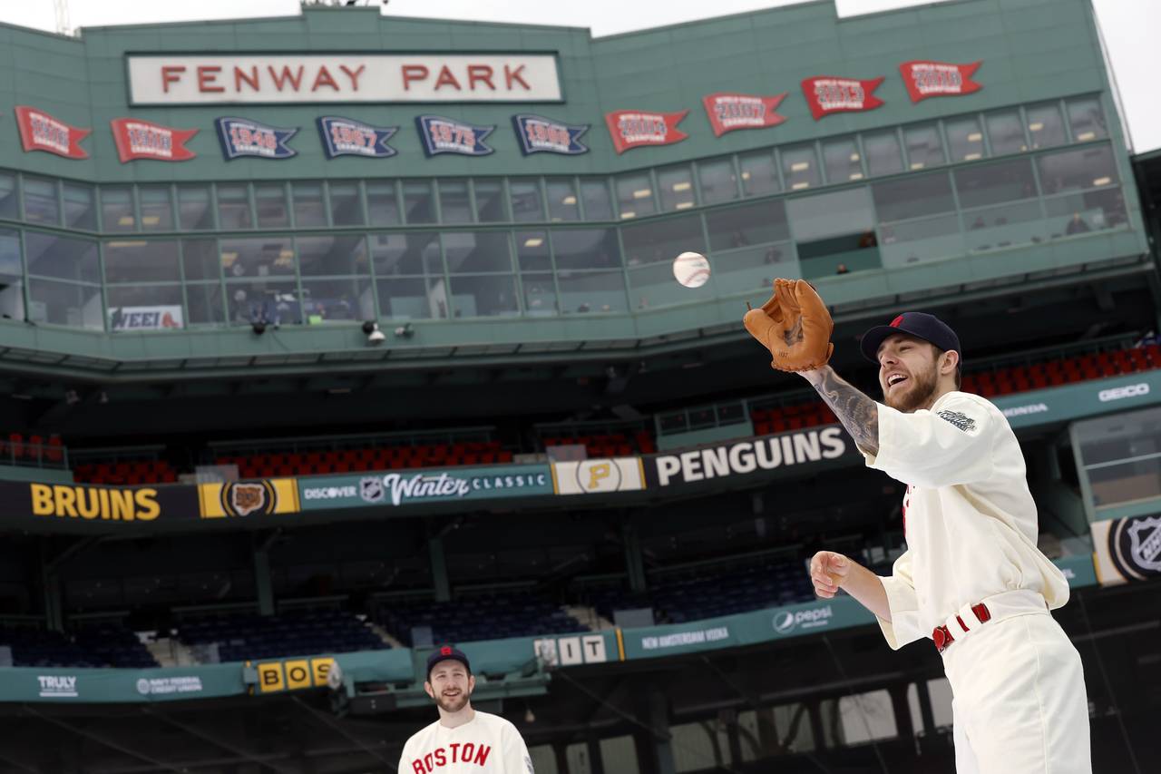 Boston Bruins' A.J. Greer, right, plays catch in a vintage Boston Red Sox uniform before the NHL Wi...