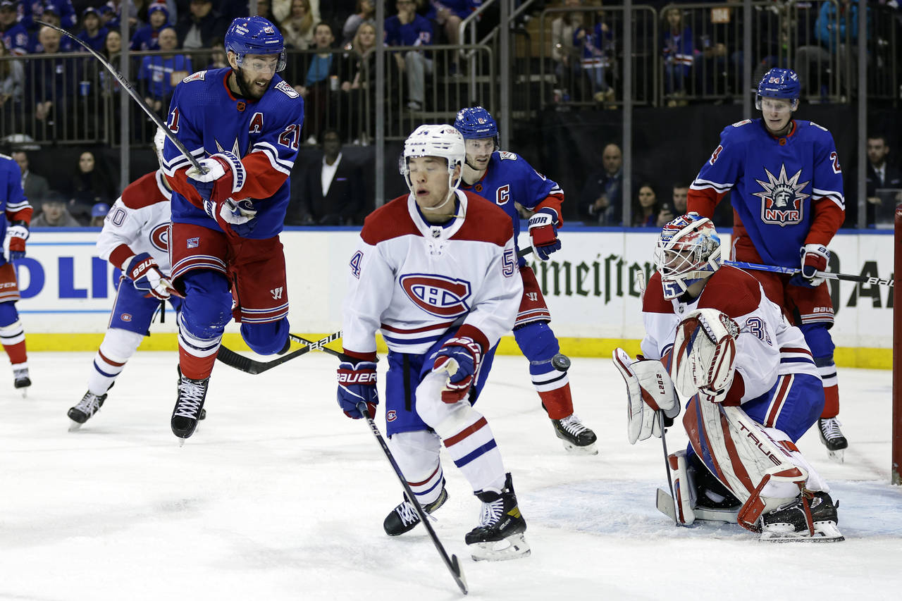 Montreal Canadiens goaltender Sam Montembeault, front right, defends against a shot as New York Ran...