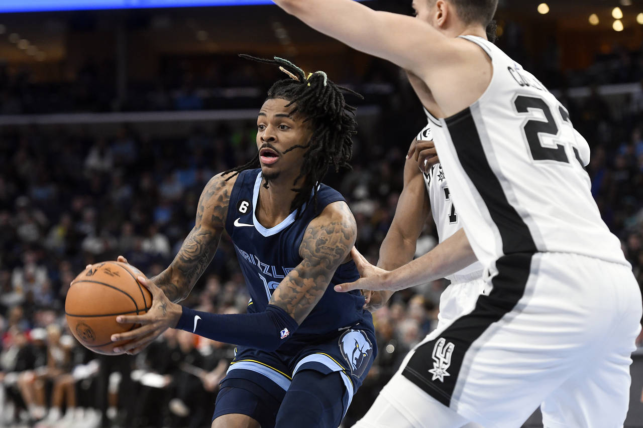 Memphis Grizzlies guard Ja Morant (12) is defended by San Antonio Spurs center Jakob Poeltl (25) an...
