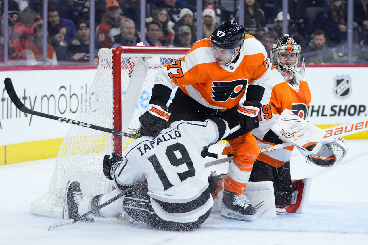 Los Angeles Kings' Alex Iafallo (19) collides with Philadelphia Flyers' Tony DeAngelo (77) and Cart...