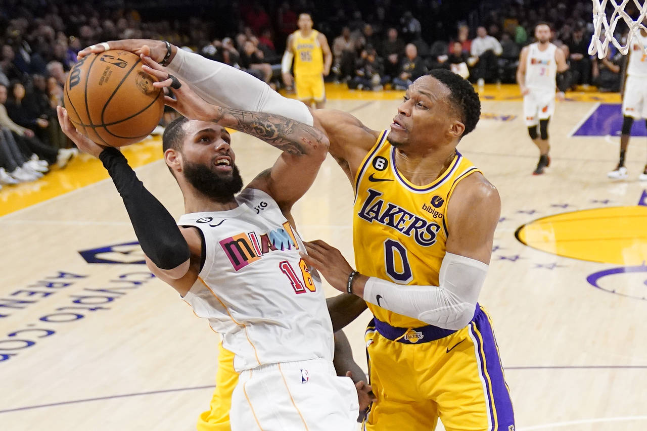 Los Angeles Lakers guard Russell Westbrook, right, blocks the shot of Miami Heat forward Caleb Mart...