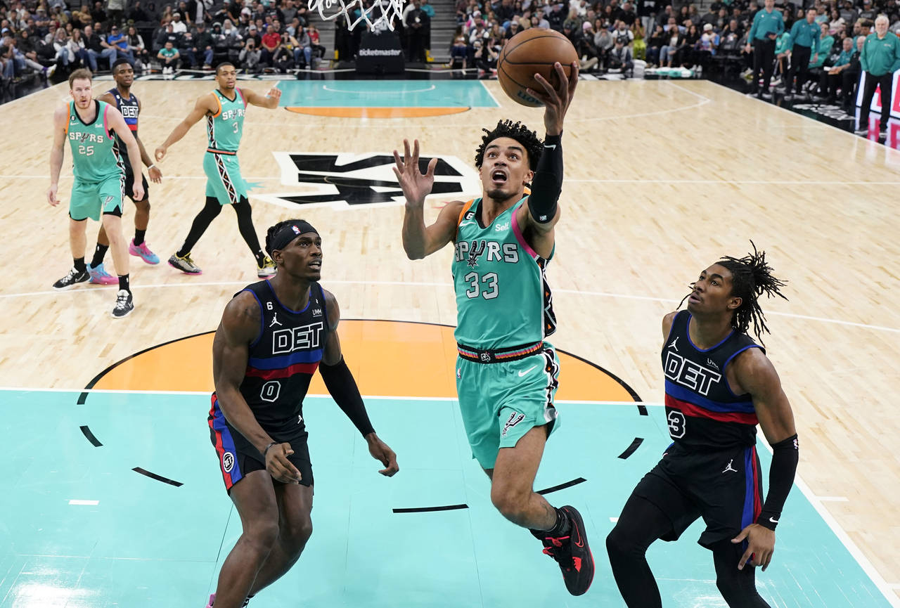 San Antonio Spurs guard Tre Jones (33) drives to the basket past Detroit Pistons center Jalen Duren...