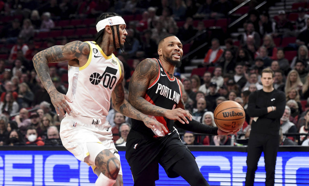 Portland Trail Blazers guard Damian Lillard, right, drives to the basket on Utah Jazz guard Jordan ...