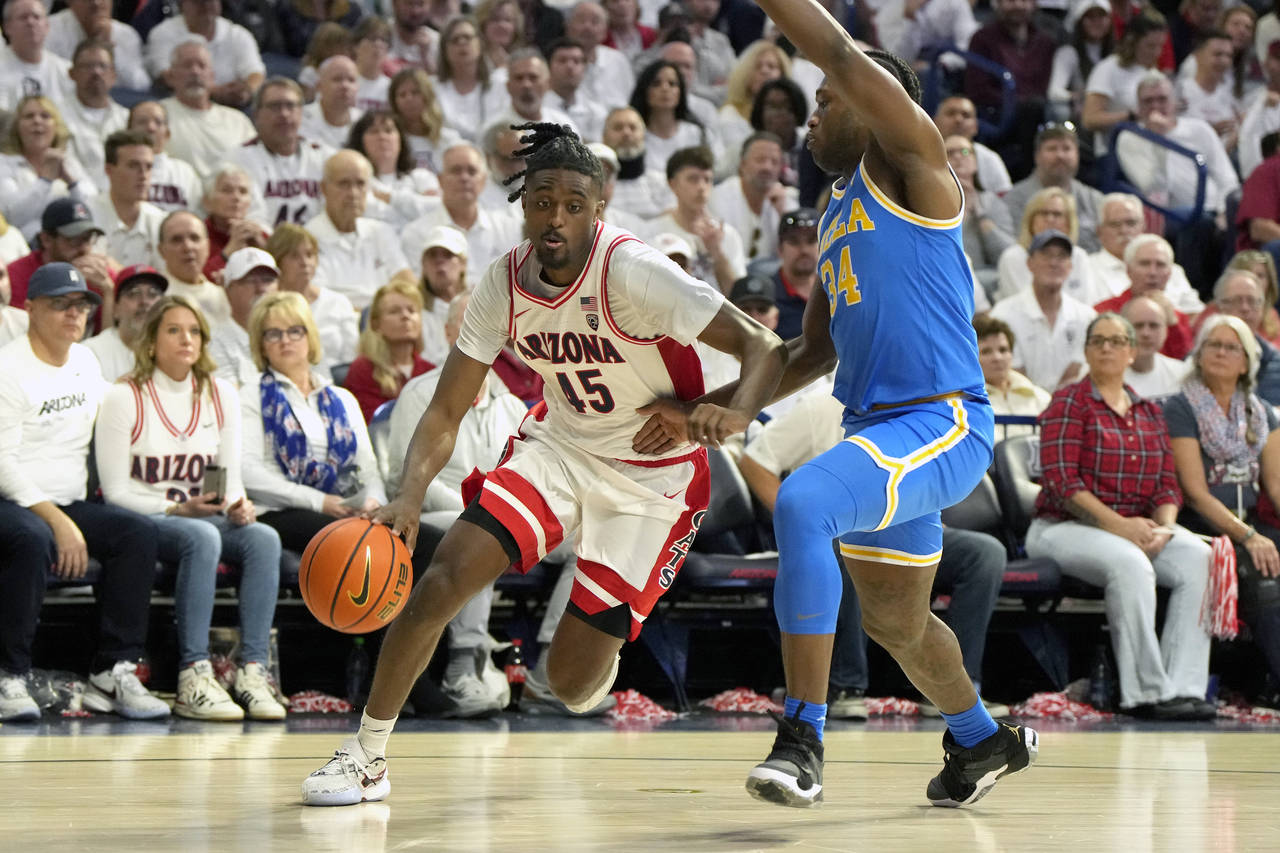 Arizona guard Cedric Henderson Jr. (45) drives on UCLA guard David Singleton during the second half...