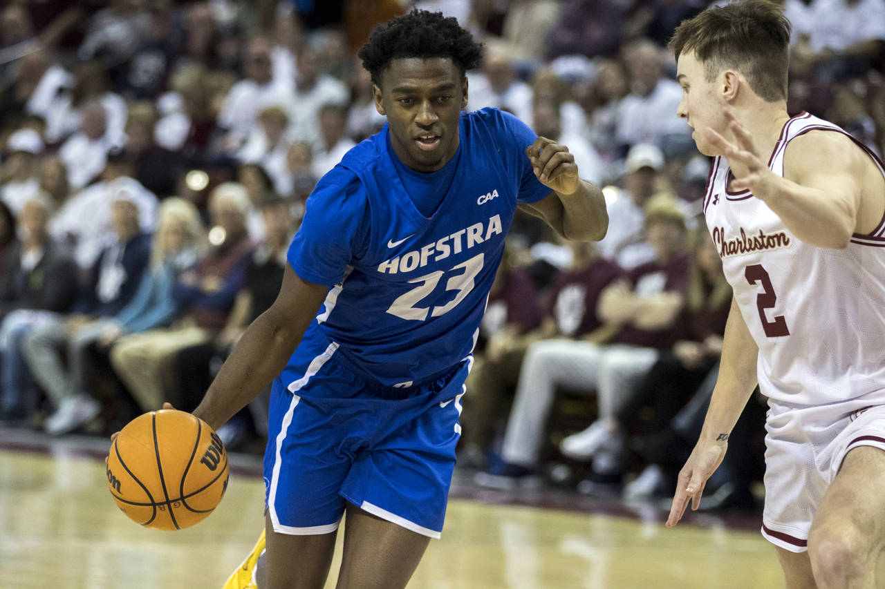 Hofstra guard Tyler Thomas (23) dribbles while guarded by Charleston guard Reyne Smith (2) during t...
