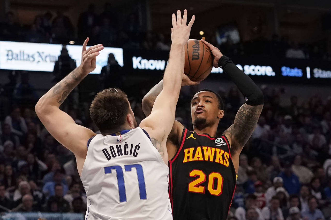 Atlanta Hawks forward John Collins (20) shoots against Dallas Mavericks guard Luka Doncic (77) duri...