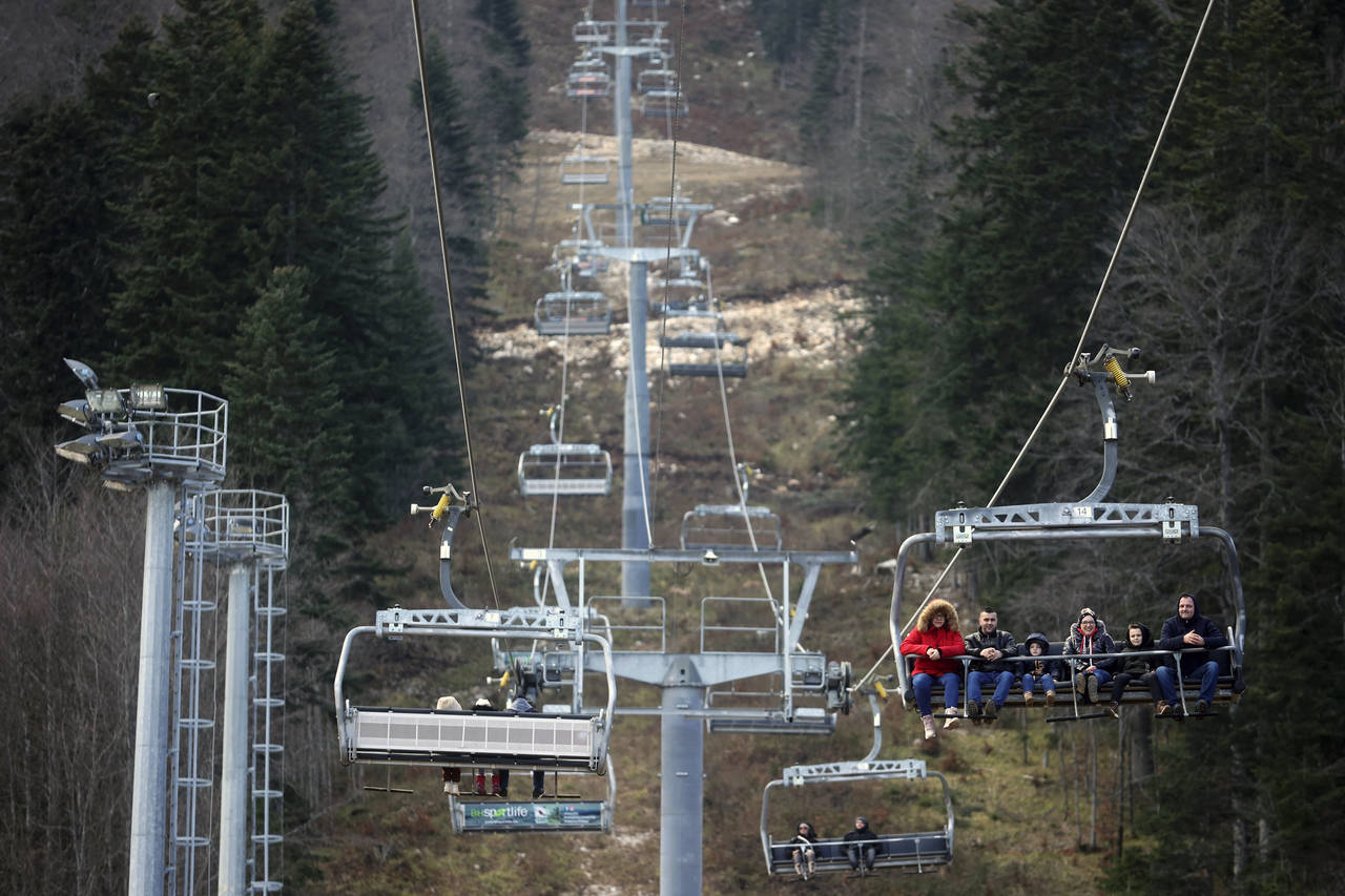 People ride the cable car above the ski track without any snow on Bjelasnica mountain near Sarajevo...