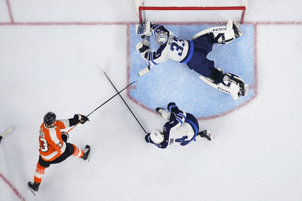 Winnipeg Jets goaltender David Rittich (33) dives to make a save on a shot from Philadelphia Flyers...