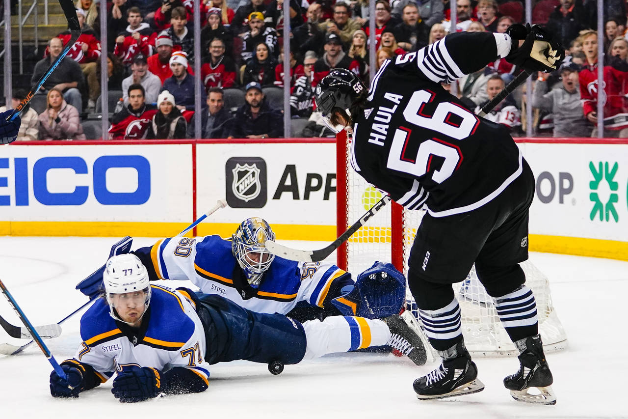 St. Louis Blues' Niko Mikkola (77) and goaltender Jordan Binnington (50) stop a shot by New Jersey ...