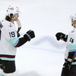 
              Seattle Kraken's Jared McCann (19) celebrates his hat trick with Justin Schultz during the third period of the team's NHL hockey game against the Chicago Blackhawks on Saturday, Jan. 14, 2023, in Chicago. (AP Photo/Charles Rex Arbogast)
            