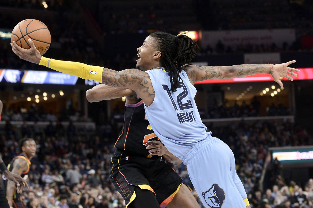 Memphis Grizzlies guard Ja Morant (12) shoots against Phoenix Suns forward Mikal Bridges in the sec...