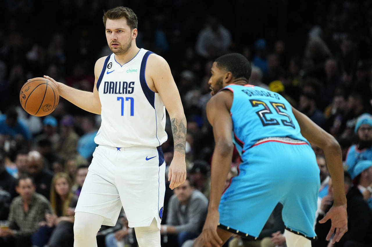 Dallas Mavericks guard Luka Doncic (77) moves the ball up court as Phoenix Suns forward Mikal Bridg...