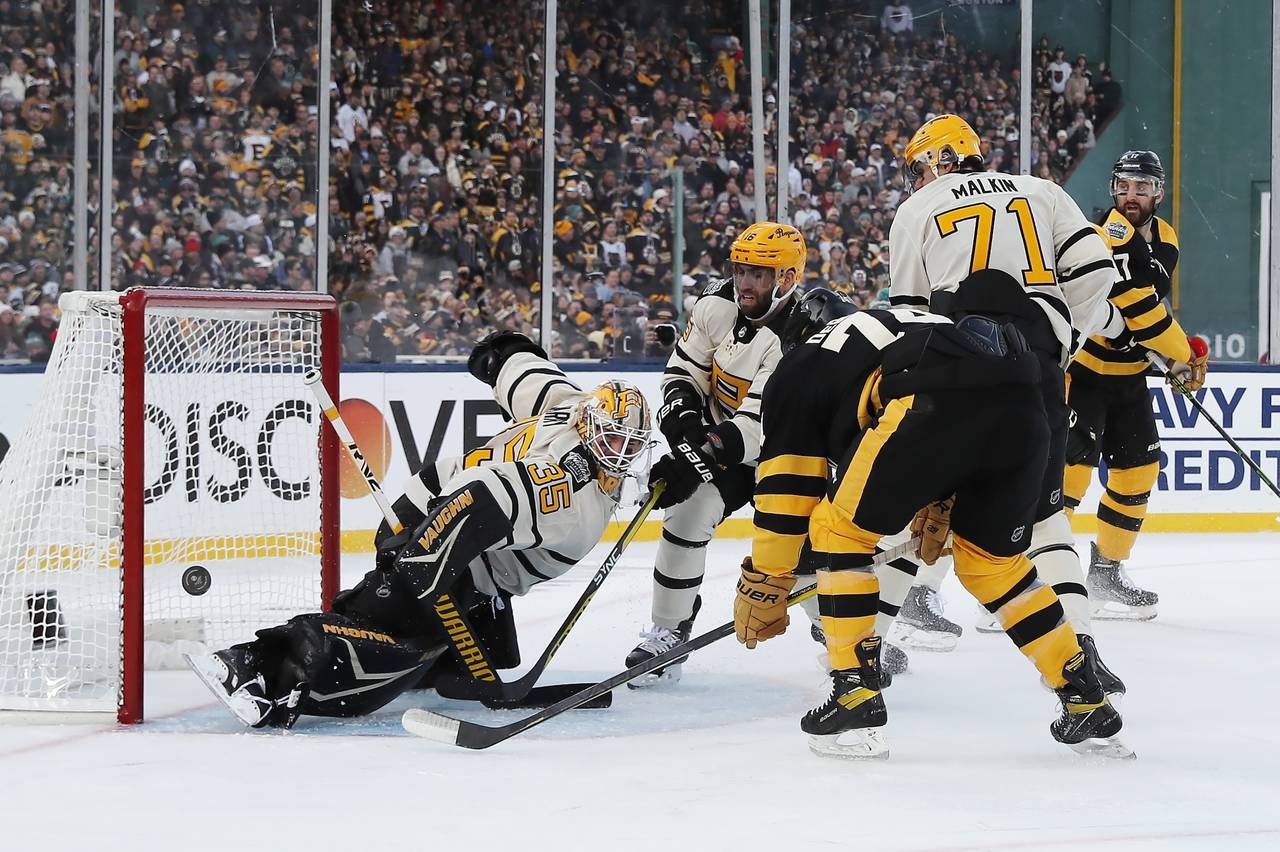 Pittsburgh Penguins goalie Tristan Jarry (35) deflects a shot in front of Boston Bruins' Jake DeBru...
